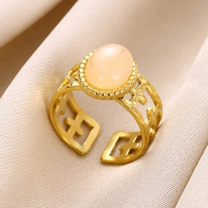 Macro detail of natural stone ring featuring a gold band with cross-shaped hollow patterns