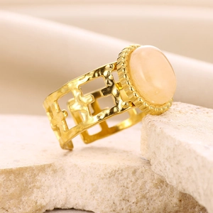 Macro detail of 18K gold hammered ring with pink oval stone on stone display