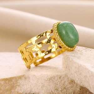 Macro shot of 18K gold plated ring with green natural stone and hollow cross design