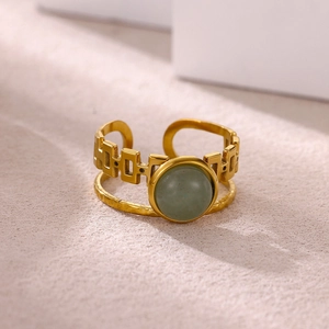 Macro detail of French vintage gold ring with green natural stone and chain link band