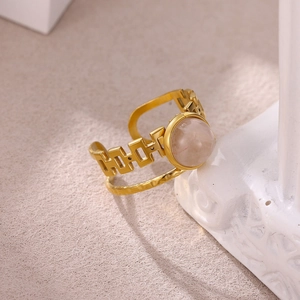 Close-up of vintage gold ring featuring pink natural stone and dual-layer geometric design