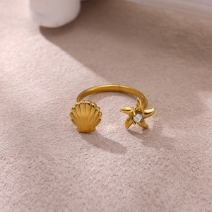 Dettaglio dell'anello regolabile dorato con stella marina conchiglia e zircone