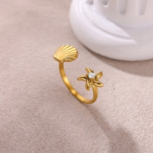 Dettaglio dell'anello dorato con stella marina e conchiglia su colonna decorativa