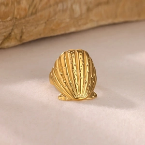 18K gold plated stainless steel seashell ring standing on natural sand background