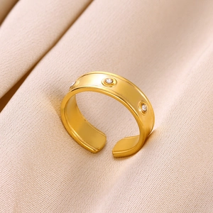 Détail d'une bague dorée réglable avec cristaux incrustés sur de la soie champagne