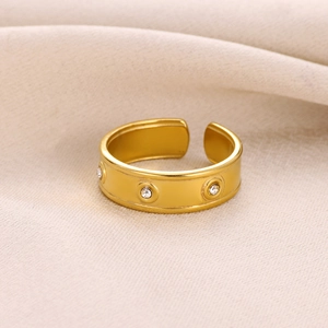 Détail d'une bague dorée ajustable avec motifs en cristal sur un tissu de soie doux