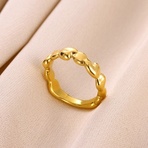 Détails de la bague à maillons en forme de cœur doré sur fond de tissu satiné rose