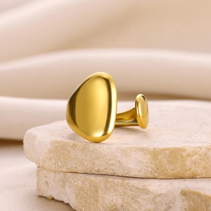 Vue détaillée d'une bague ouverte dorée géométrique aux galets asymétriques polis