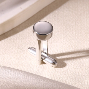 Detailed macro view of silver round cufflinks with a high-polished mirror finish
