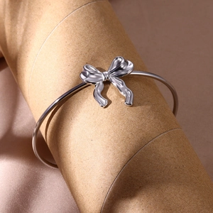 Vue détaillée du bracelet jonc avec nœud papillon argenté poli sur un support de présentation