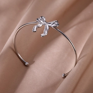 Bracelet jonc élégant en acier inoxydable avec nœud texturé sur fond de soie luxueux