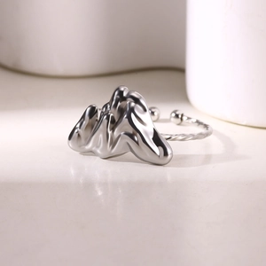 Macro shot of silver adjustable rope ring with polished fluid metal design and mirror finish