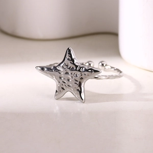 Macro detail of silver starfish ring with hammered texture and adjustable twisted band