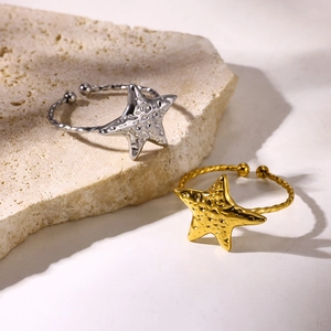 Makroaufnahme von Sternringen mit Hammerschlag-Textur und gedrehtem Band in Gold und Silber
