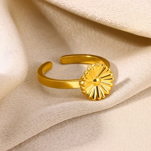 Detailed close-up of a golden sunflower adjustable ring on champagne satin fabric