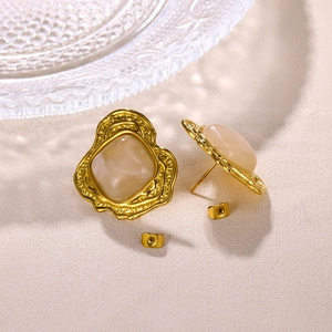 Nahaufnahme der Vintage 18K Gold Ohrringe mit quadratischen Perlen auf Stoffoberfläche