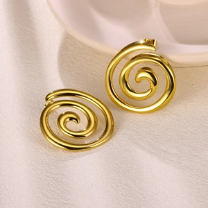 Detailansicht der vergoldeten Spiral-Ohrstecker auf einem eleganten Keramiktablett