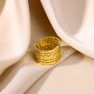 Macro shot of gold-plated multi-layer rings with daisy floral carvings on silk