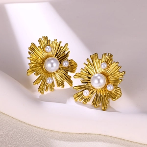 Makroaufnahme von vergoldeten Edelstahl-Blumenohrringen mit weißen Perlen