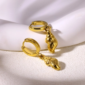 Detail view of golden conch shell dangle earrings with elegant polished huggie hoops