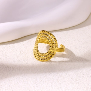 Detailed close-up of a hollow geometric gold ring with triple-layered textured patterns