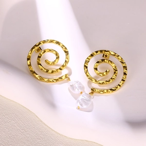 Detail von 18 Karat vergoldeten Spiralohrringen mit einer weißen Barockperle auf einer Struktur