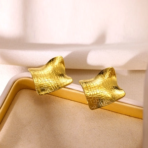 Detailed view of square gold-plated earrings with unique textured grid pattern surface