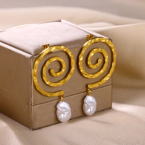 Detail der goldenen Spiralstruktur und Barockperlen an 18K vergoldeten Ohrringen