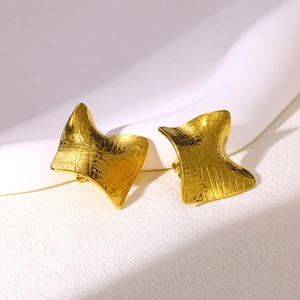 Detail of gold geometric earrings featuring a modern textured cross-grid pattern