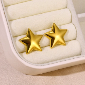Close-up of gold-plated star stud earrings set in a soft cream velvet jewelry box