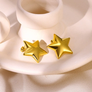 Polished gold stainless steel star earrings displayed on a ceramic base for women