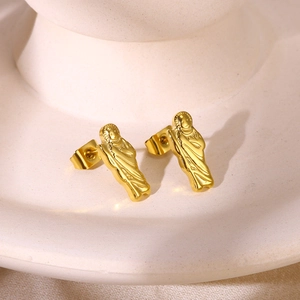 Macro detail of gold plated religious portrait stud earrings with butterfly backings