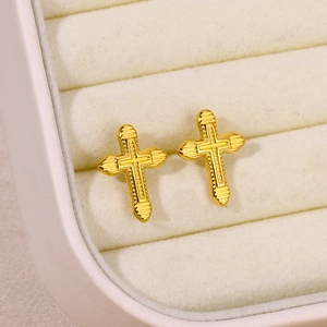 Detail of gold-plated stainless steel cross earrings with textured geometric stripes