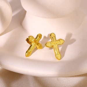 Detail of gold-plated cross stud earrings with textured surface and butterfly backing