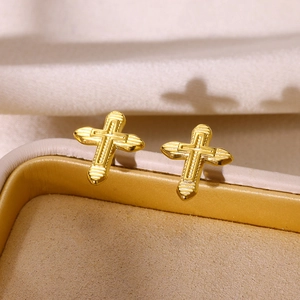 Close-up of gold-plated stainless steel cross earrings with fine striped texture detail