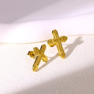 Detail of gold-plated stainless steel cross earrings with embossed stripe texture