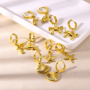 Five pairs of golden ocean-themed hoop earrings featuring crab, dolphin and starfish charms