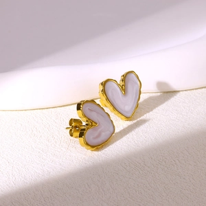 Detail view of heart-shaped gold-plated stainless steel earrings with lilac enamel inlay