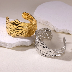 Macro shot of gold and silver chunky bangles with irregular hammered lava texture