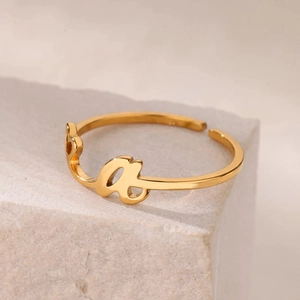 Detalle de anillo ajustable bañado en oro con elegante diseño de letra a en letra cursiva