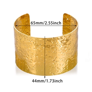 Macro shot of gold wide cuff bracelet showing irregular texture and dimensions 65mm by 44mm