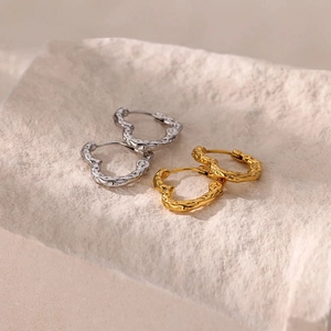 Vue détaillée de boucles d'oreilles cœur avec texture lave martelée et finition métallique