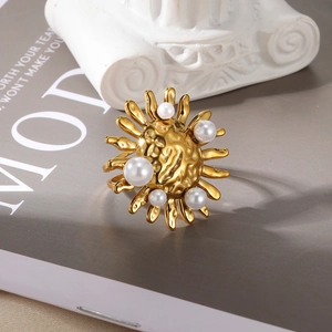 Detailed close-up of a gold pearl ring with vintage lava texture on a magazine page
