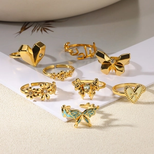 Set of 8 gold stainless steel rings featuring heart, butterfly and floral designs