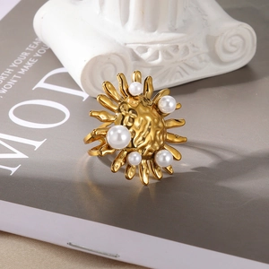 Detailed view of sun-shaped gold ring with white pearls and hammered metal texture