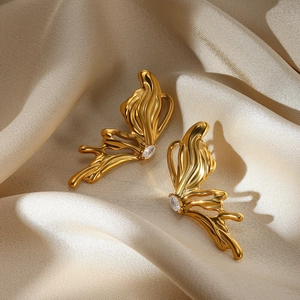 Boucles d'oreilles papillon dorées 18 carats avec zircone sur fond de soie élégante