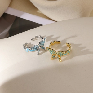 Detail of adjustable butterfly open rings in gold and silver with blue enamel wings