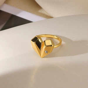 Macro shot of gold heart ring with geometric facets and a small inset white zircon stone