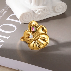 Detailed macro view of gold flower ring with pearl and zircon on a magazine