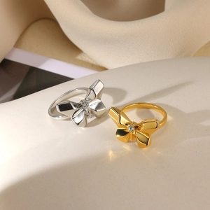 Close-up of gold and silver butterfly rings with rhinestones on a decorative base